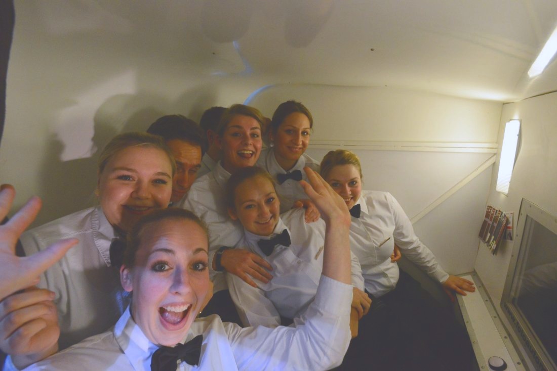 Eine Gruppe drängt sich lachend in die Fotokabine von Flash-U