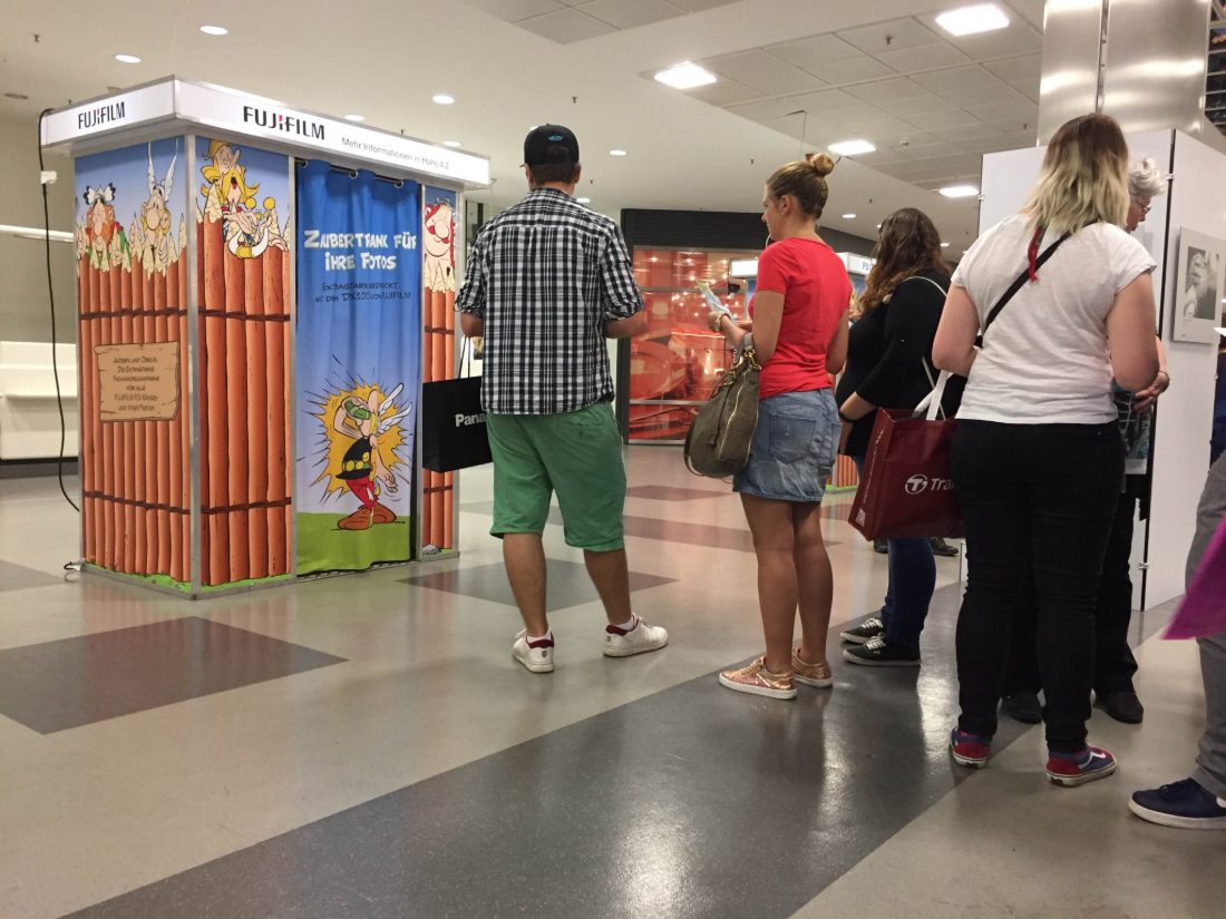 Gäste stehen Schlange vor einem gebrandeten Fotoautomaten von Flash-U