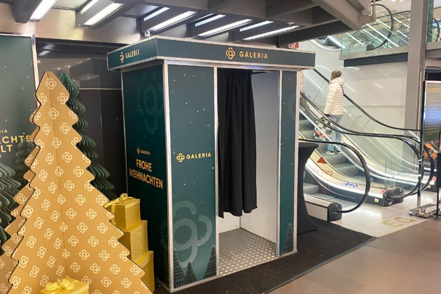 Fotokabine von Flash-U in weihnachtlicher Gestaltung zwischen den Rolltreppen eines Kaufhauses