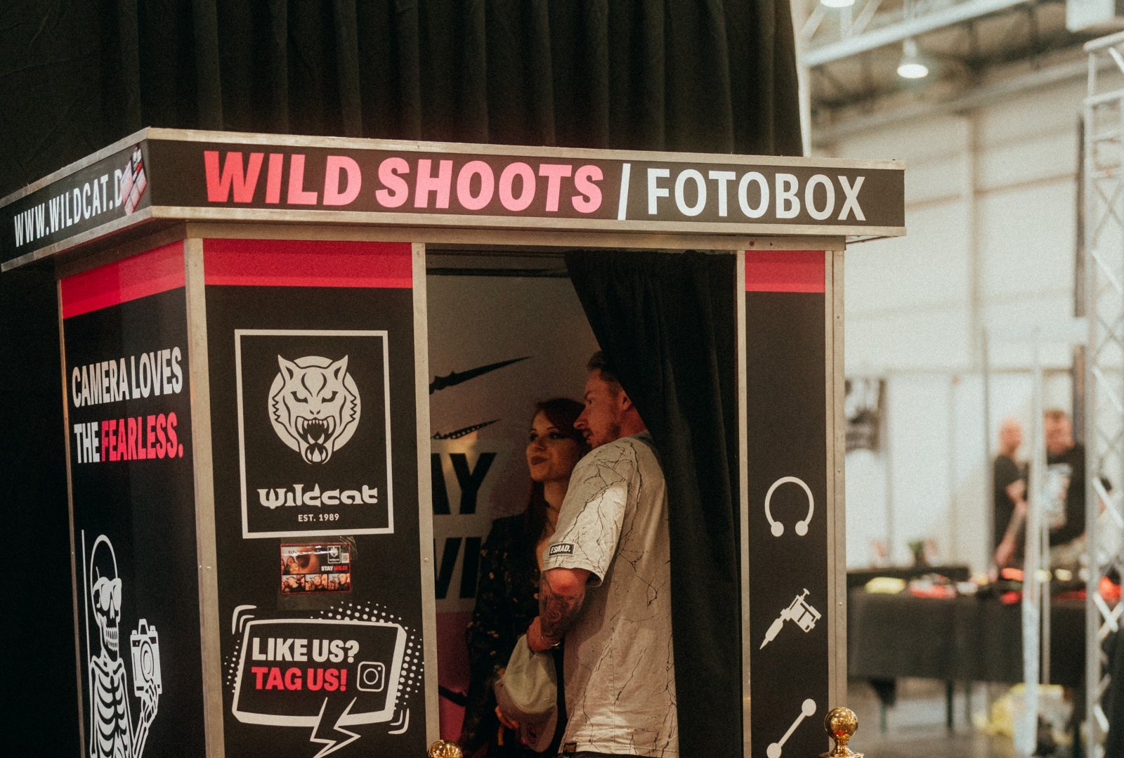 Zwei Gäste in einer Fotokabine von Flash-U im Design der Marke Wildcat auf einer Convention
