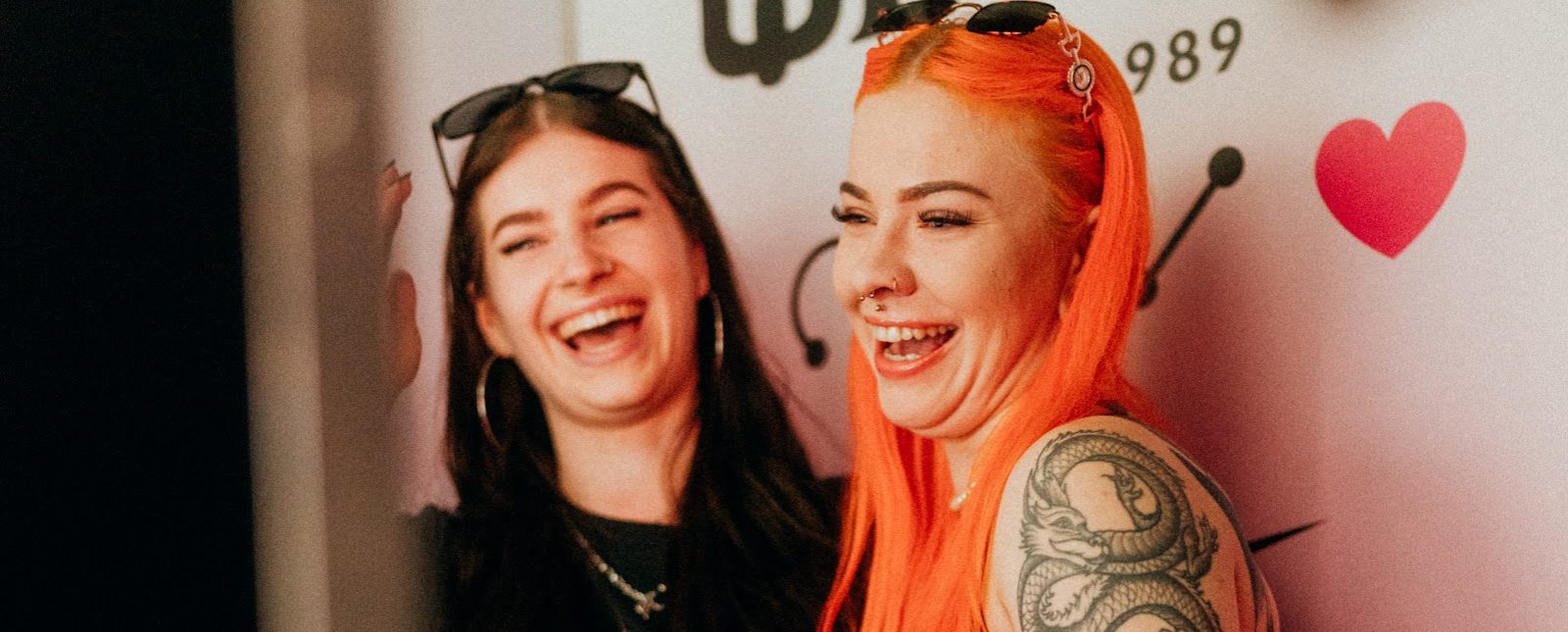 Zwei lachende Gäste in der gebrandeten Fotokabine von Flash-U auf der Tattoo Convention Dortmund