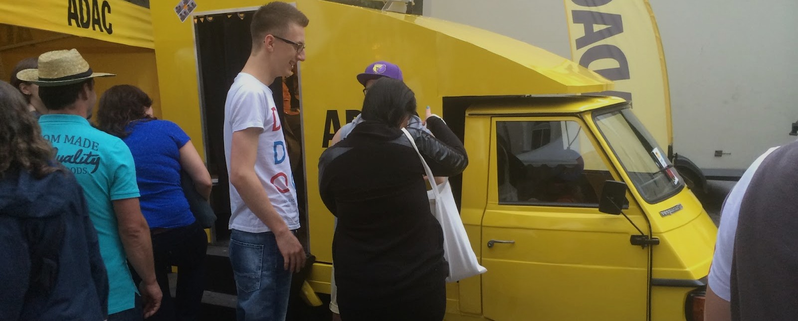 Warteschlange am gelben Fotomobil von Flash-U bei einem Sommerfest